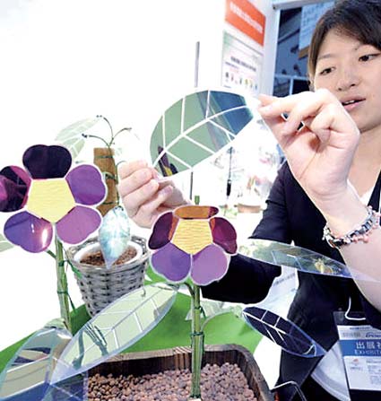 2008年在日本东京的一个太阳能展览上，一名日本产业技术综合研究所的职工展示被制作成花朵和叶子形状的太阳能电池模型。